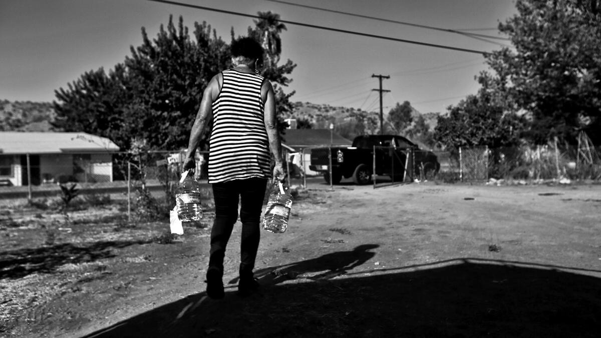 Donna Johnson lugs bottled water for some of the hundreds around East Porterville whose wells have gone dry. She realized others might need help after her own well went dry in June.