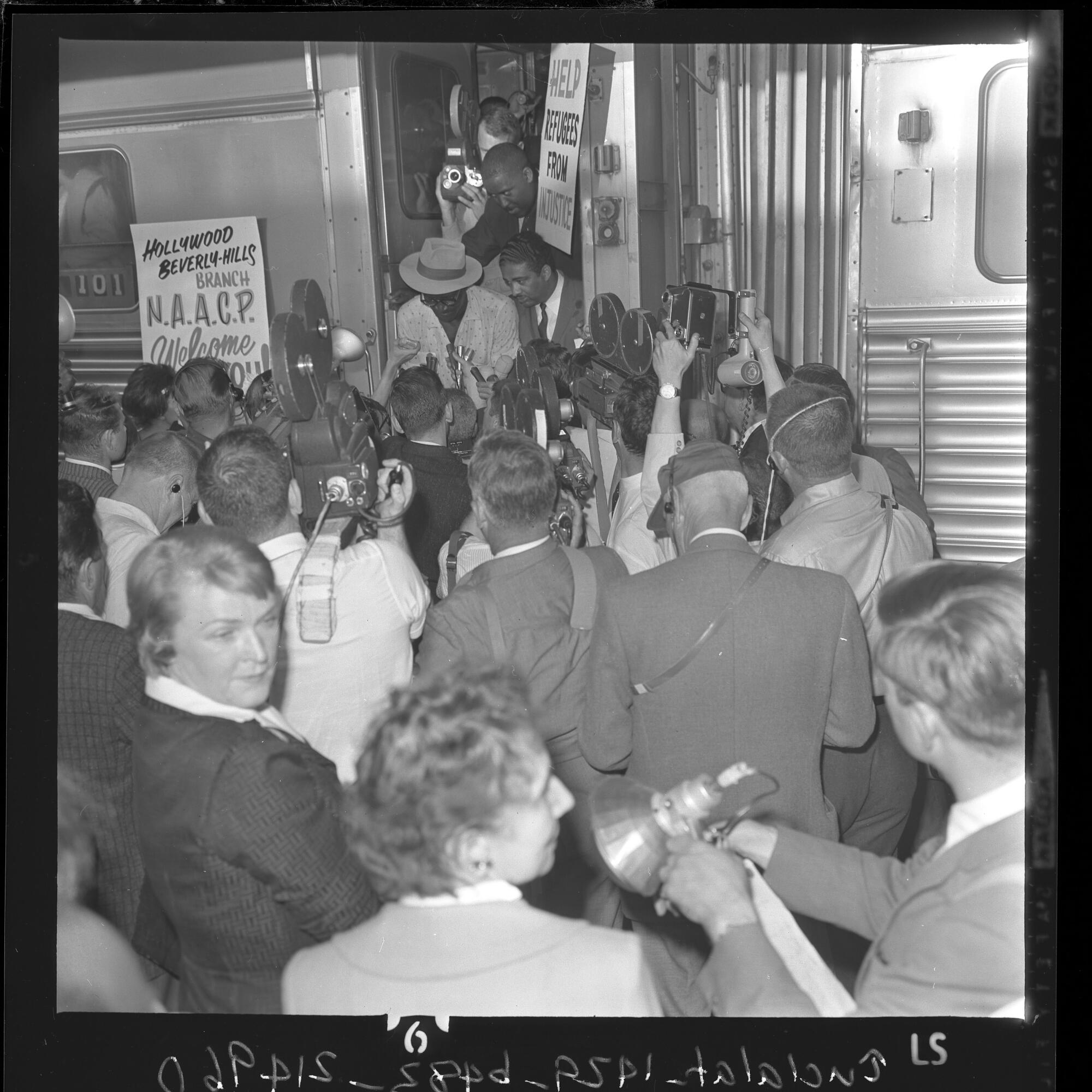 A crowd greets people disembarking a train from Louisiana and looking for work.