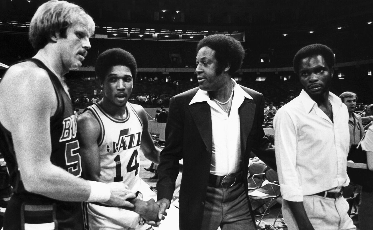 New Orleans Jazz Coach Elgin Baylor (in coat) shakes with, from left, Kent Benson of the Milwaukee Bucks, Tommy Green of the Jazz and Jimmy McElroy of the Jazz, who did not dress out for the Jazz-Bucks game in the Louisiana Superdome in New Orleans April 7, 1979.