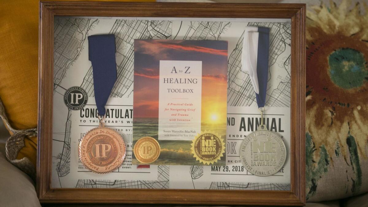 A shadow box showcases Susan Hannifin-MacNab's book "A to Z Healing Toolbox" and two of the three awards it has won.