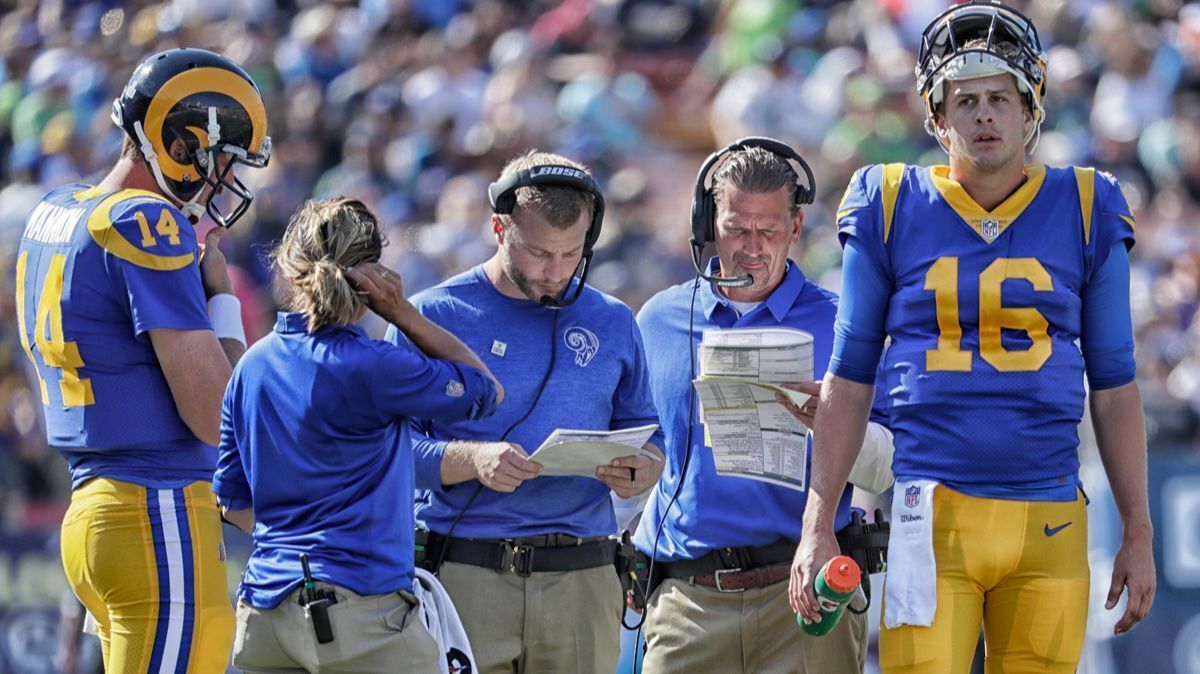 Rams head coach Sean McVay, third from left left, and quarterbacks coach Greg Olson look over the play sheets while backup quarterback Sean Mannion, left, and starting quarterback Jared Goff stand nearby during a break against the Seattle Seahawks at the Coliseum on Oct. 8, 2017.