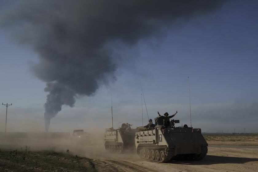 Israeli soldiers move on armored personnel carriers (APC) near the Israeli-Gaza border as smoke rises to the sky in the Gaza Strip, seen from southern Israel, Sunday, Jan. 21, 2024. (AP Photo/Leo Correa)