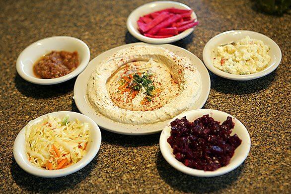 Glatt Gulch is an affectionate nickname for a 15-block stretch of Pico Boulevard in L.A.'s Westside that serves as an introduction to the world of Israeli cuisine. The Glatt kosher foods featured in this gallery are from Haifa Restaurant. Here, clockwise from top left, small plates of freshly made baba ghanouj, pickles, egg salad, beet salad and coleslaw surround a plate of hummus.