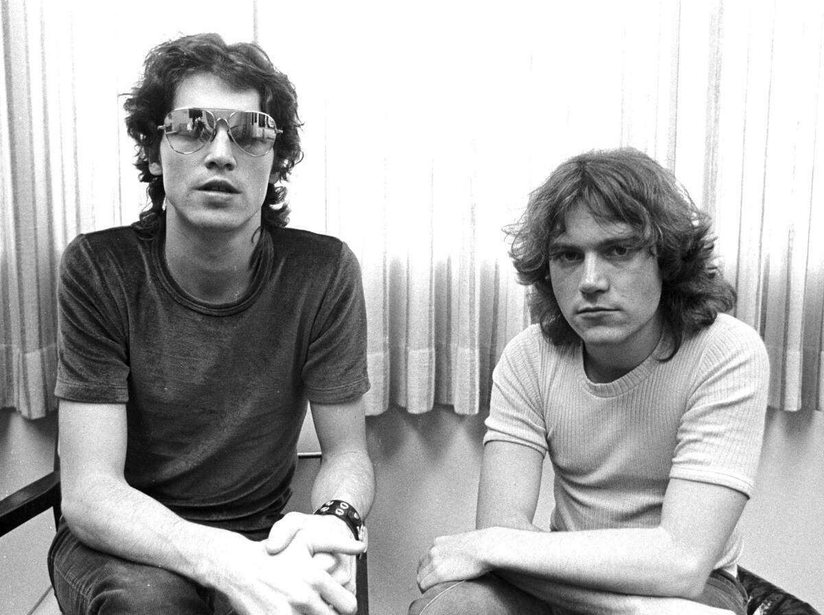 Two rock musicians pose for a photo in the 1970s