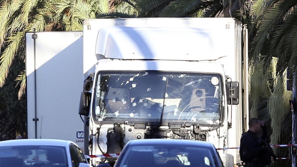 The truck that plowed through Bastille Day revelers, its windshield riddled with bullets, is examined by forensics officers in Nice, France.