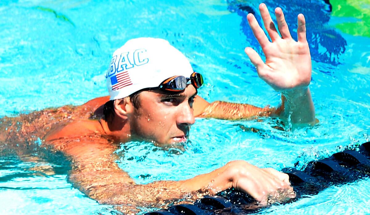 Michael Phelps acknowledges the applause after winning his heat in the 100-meter butterfly preliminaries at the national championships Friday at the Woollett Aquatics Center in Irvine.