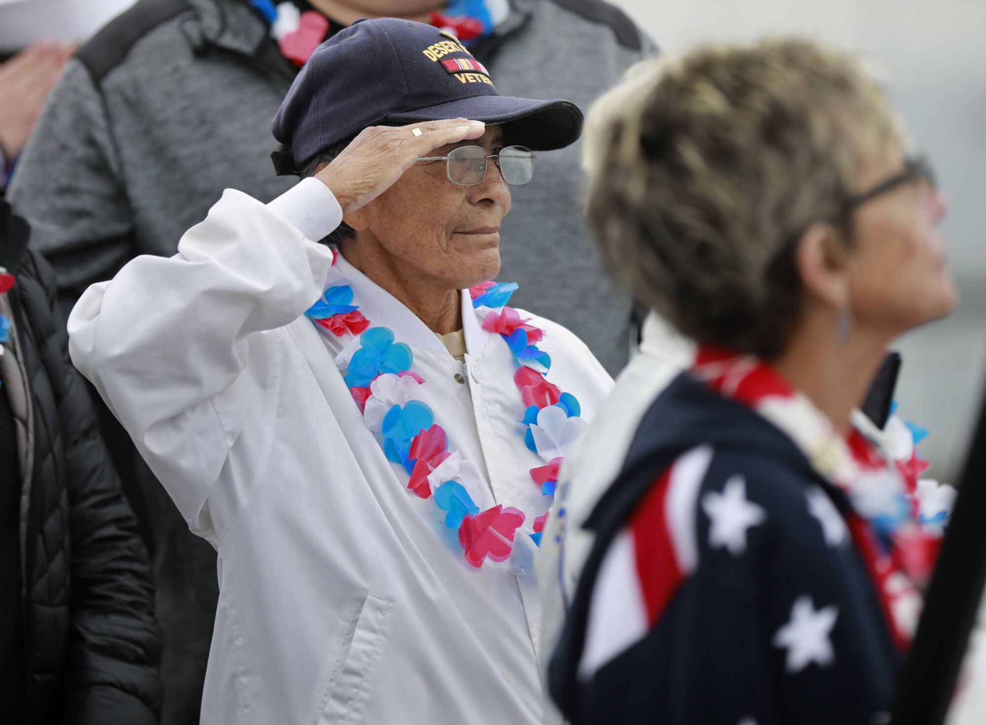 Kathleen Chavez, the daughter of the late Pearl Harbor attack Ray Chavez, salutes
