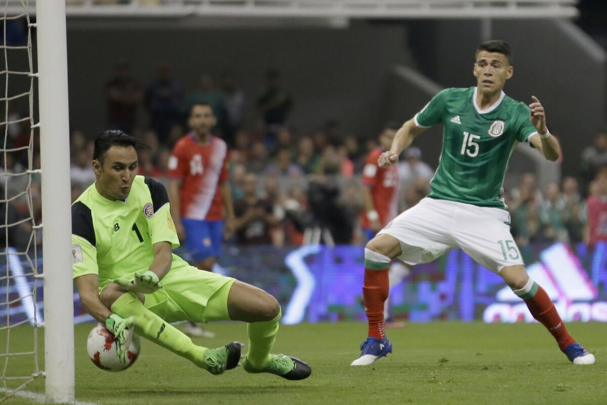 El arquero de Costa Rica Keylor Navas no logra atajar un remate a gol del mexicano Néstor Araujo .