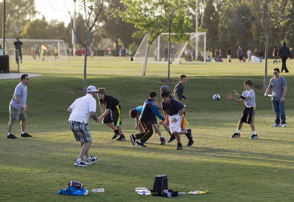 Teams with Newport-Mesa Friday Night Lights practice at Jack Hammett field in 2014. The league's status in Costa Mesa next fall is in question after it lost its priority status for use of local athletic fields.