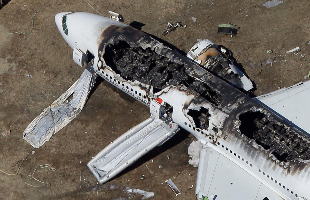 A Boeing 777 airplane lies burned near the runway after it crash-landed at San Francisco International Airport.