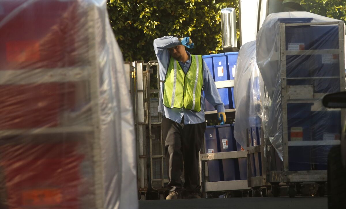 A worker is surrounded by containers filled with biohazardous waste in Vernon.