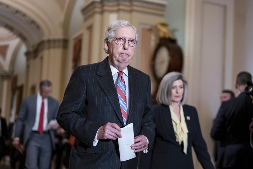 Senate Minority Leader Mitch McConnell, R-Ky., joined at right by Sen. Joni Ernst, R-Iowa, arrives to speak to reporters after a Republican strategy meeting at the Capitol in Washington, Tuesday, March 8, 2022. (AP Photo/J. Scott Applewhite)