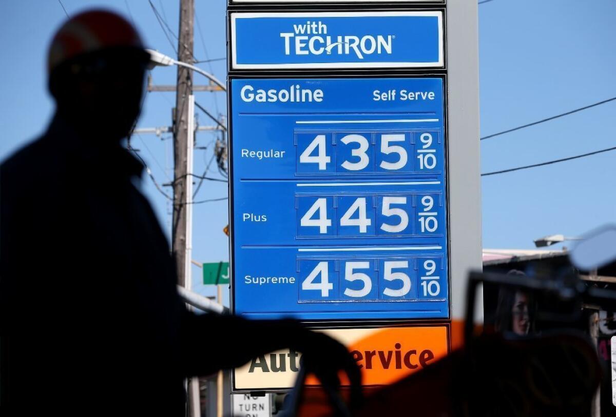 Gas prices are displayed as a motorcyclist fuels his motorcycle at a Chevron gas station in San Francisco.