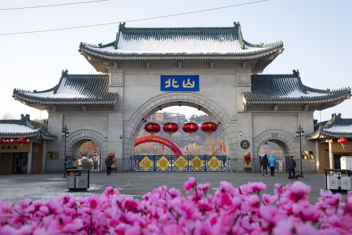 Tourists walk past a gateway to Beishan Park in northeastern China's Jilin province.