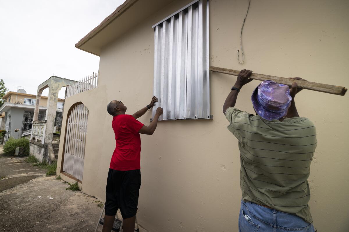 Residents prepare for the arrival of Tropical Storm Fiona, in Loiza, Puerto Rico, Saturday, Sept. 17, 2022. Fiona was expected to become a hurricane as it neared Puerto Rico on Saturday, threatening to dump up to 20 inches (51 centimeters) of rain as people braced for potential landslides, severe flooding and power outages. (AP Photo/Alejandro Granadillo)