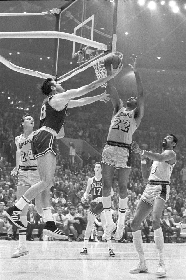 Boston's Bailey Howell whirls with a reverse layup against the Lakers on May 5, 1969, but Elgin Baylor is there to block it.