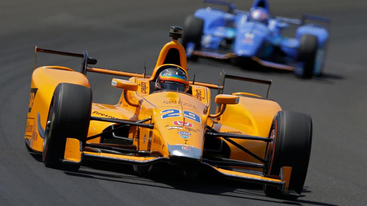 Fernando Alonso leads Scott Dixon through the first turn during practice for the Indianapolis 500 on May 22.