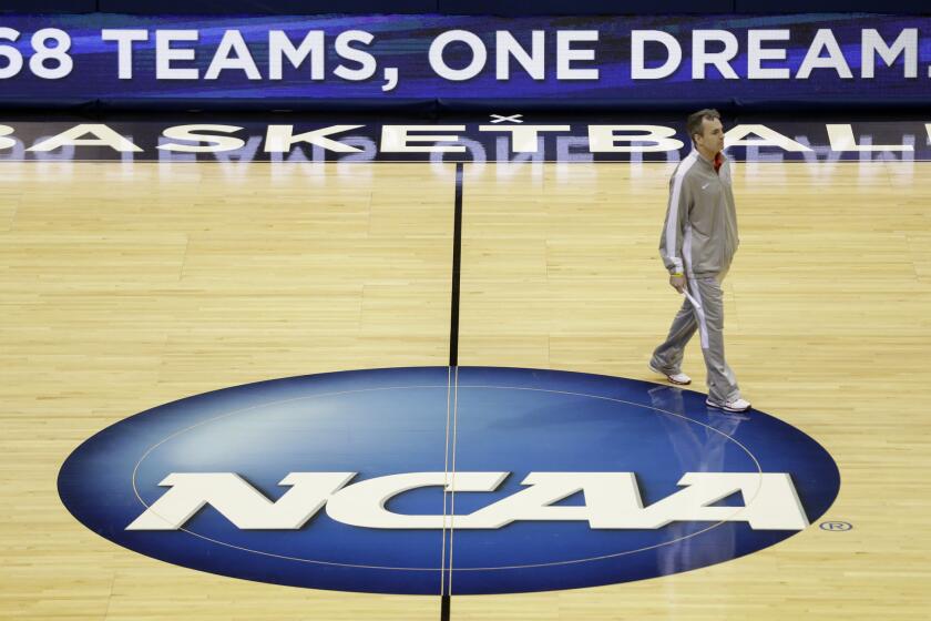 American University head coach Mike Brennan walks around the court during a practice session for the school's NCAA college basketball tournament game in Milwaukee. American plays Wisconsin on Thursday.