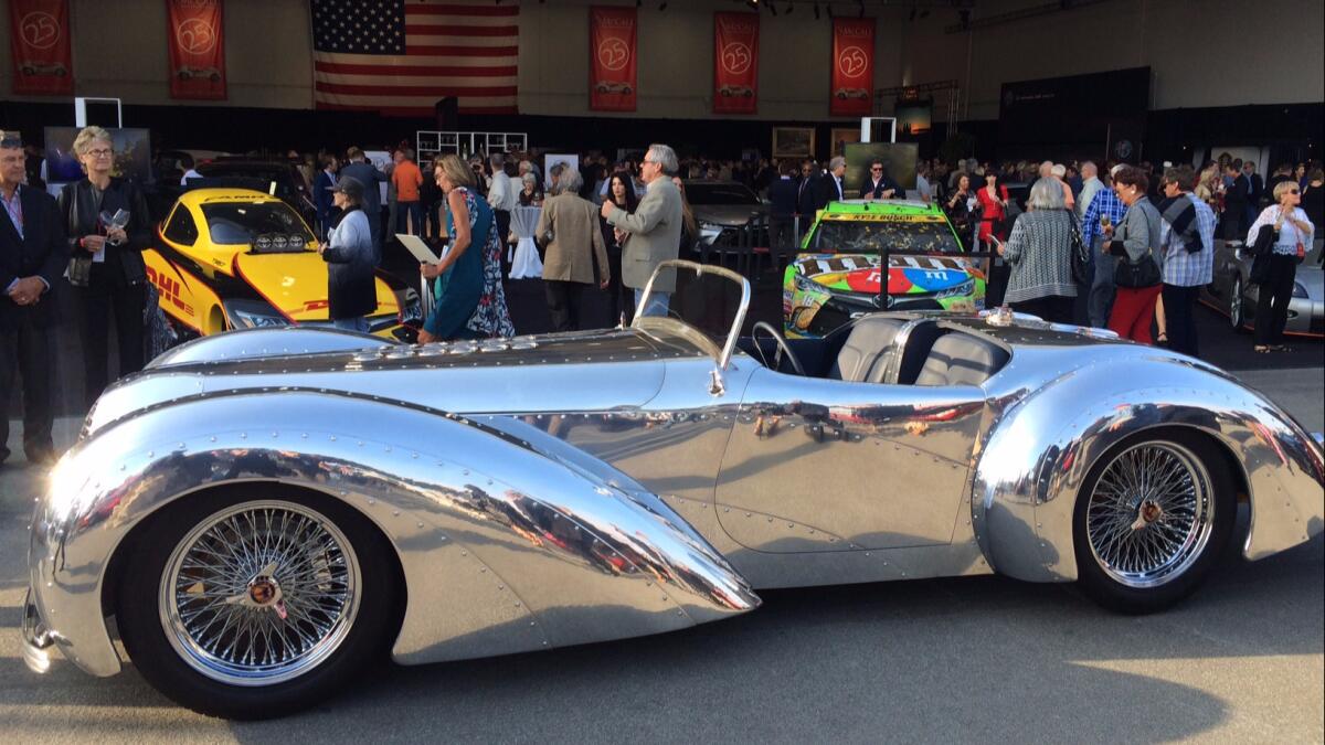 A custom car decorates a hangar opening at the annual Motorworks Revival party at Monterey Jet Center.