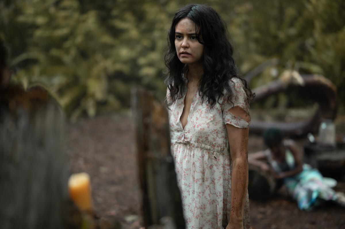 A teenage girl in the wilderness in a torn white dress