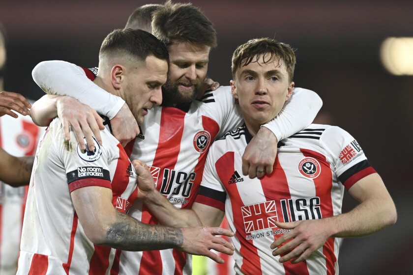 Sheffield United's Billy Sharp, left, celebrates after scoring his side's first goal during the English Premier League soccer match between Sheffield United and Newcastle United at the Bramall Lane stadium in Sheffield, England, Tuesday, Jan. 12, 2021. (Stu Forster/Pool via AP)