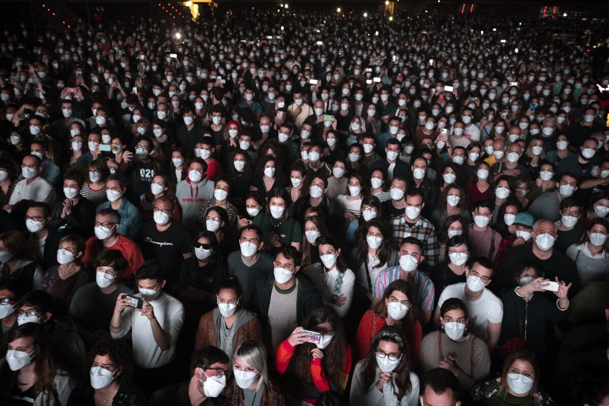 People wear face masks at a  concert 