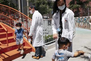 Los Angeles, CA - June 21: Callum Diaz-Cheng, 3 (left), and Aevin Lee, 2 (right), play at the Children's Hospital Los Angeles with their parents and CHLA staff, Dr. Andrew Cheng and Dr. Jennifer Su, while waiting for the children's vaccinations on Tuesday, June 21, 2022 in Los Angeles, CA. This was the hospitals first round of Pfizer vaccines approved for children five and under. (Wesley Lapointe / Los Angeles Times)