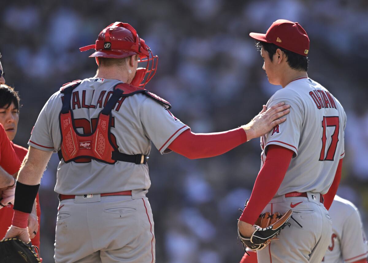 Angels pitcher Shohei Ohtani and catcher Chad Wallach stand on the mound.