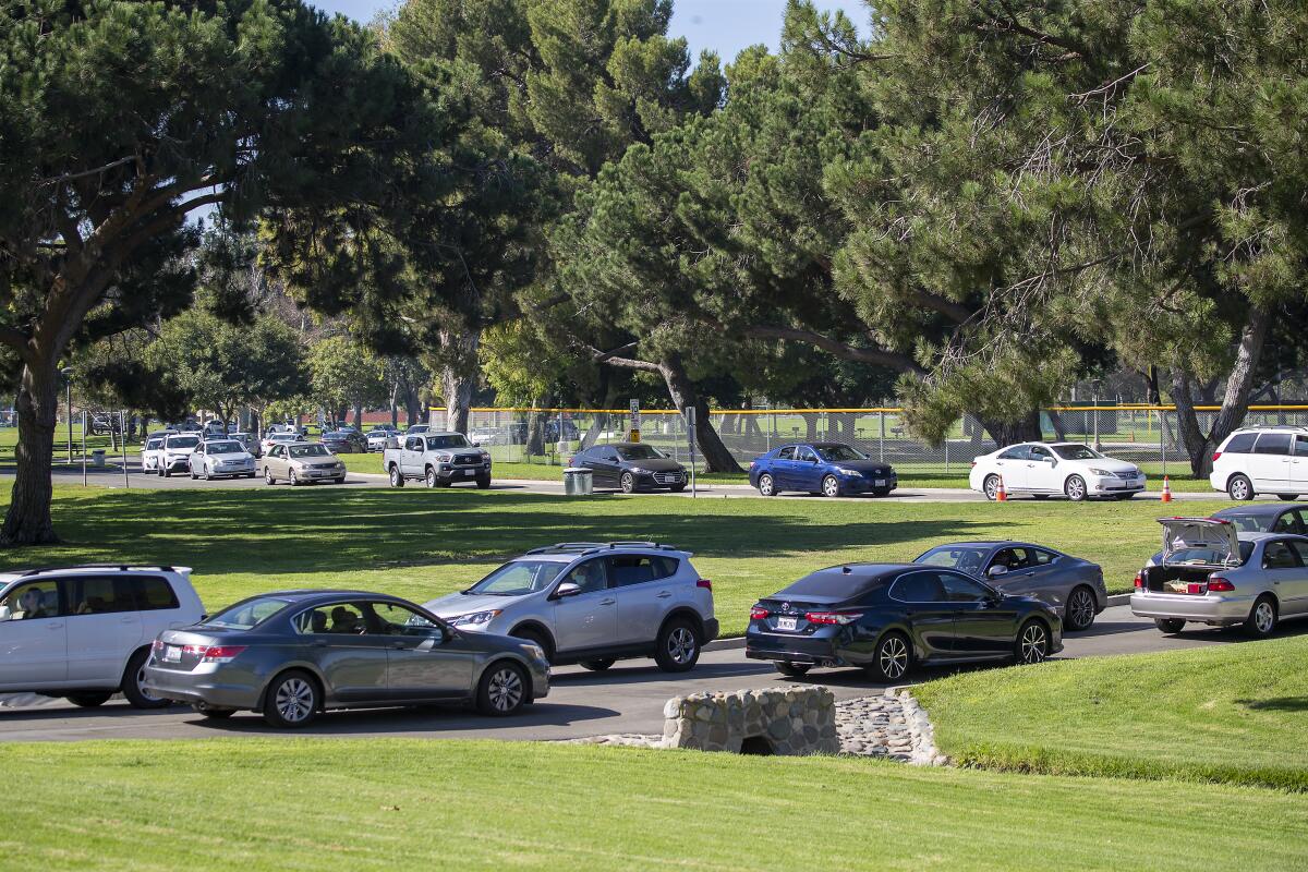 Long lines of cars wait for free food distribution in Fountain Valley.