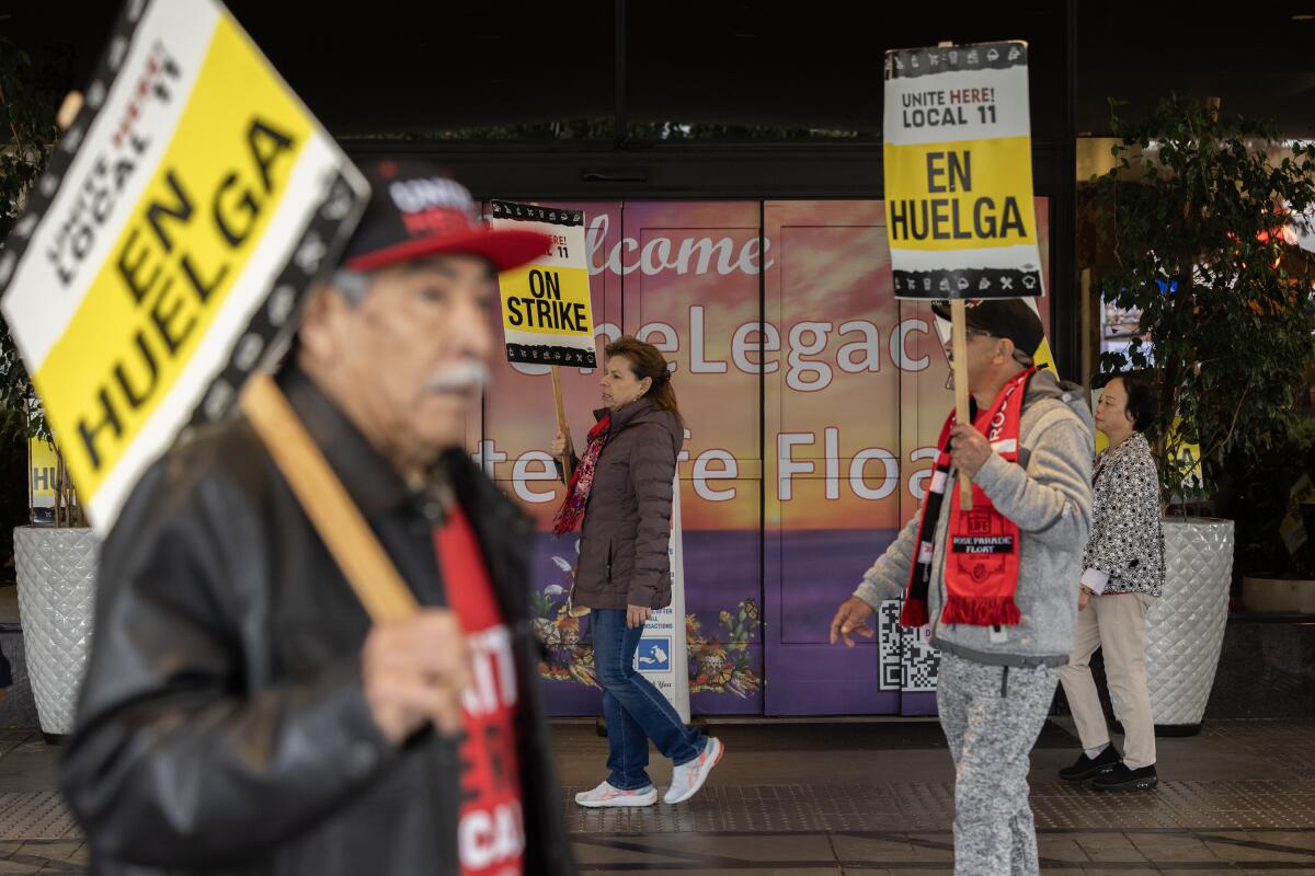Workers hold signs reading "Local 11 En Huelga."