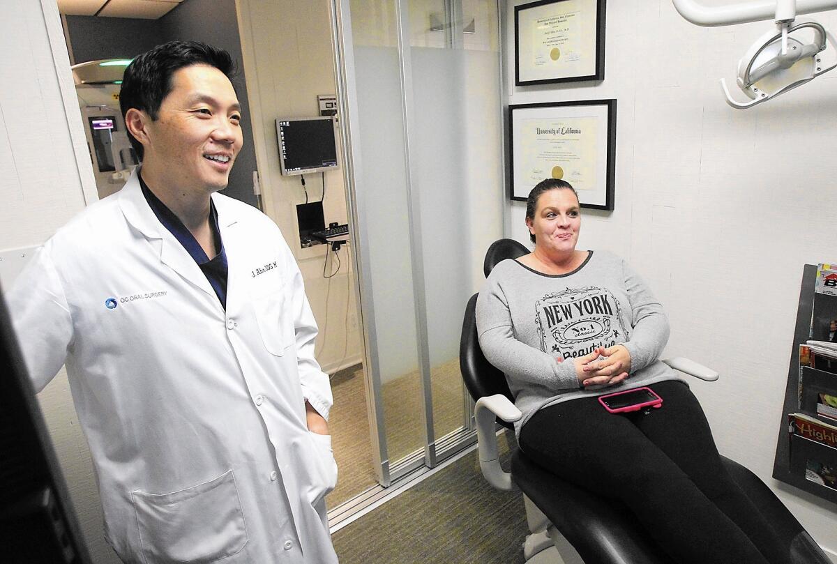Dr. Junil Ahn, left, and patient Krista Sanchez, speak about her treatment in his Mission Viejo office.