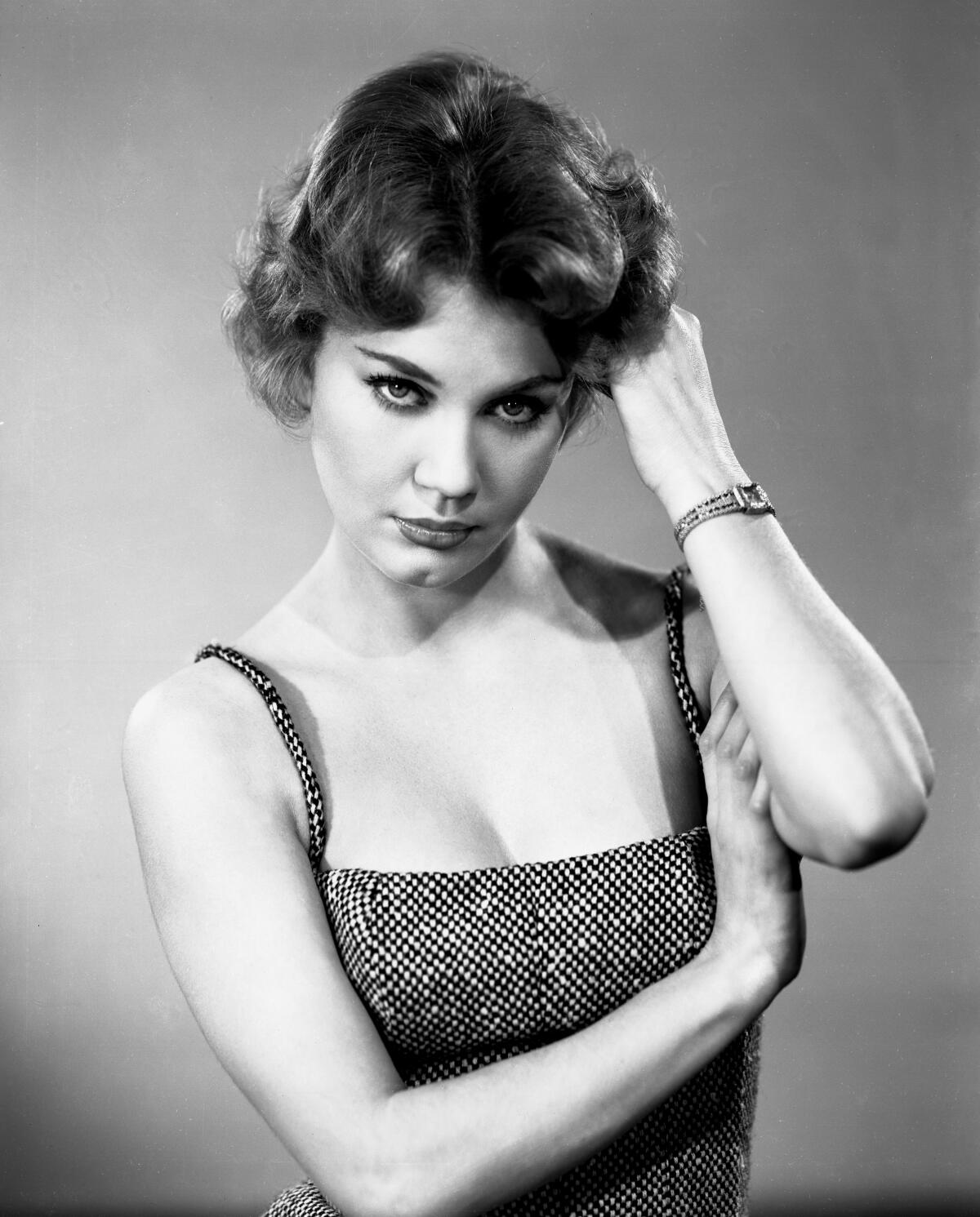 Elizabeth MacRae poses in spaghetti-strap top, with her hand in her hair, in a black-and-white portrait.