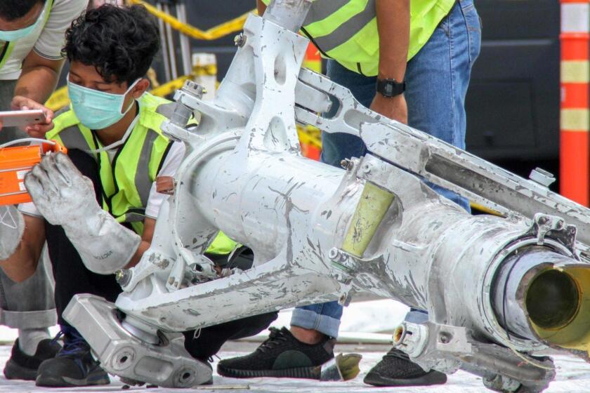 (FILES) In this file photo taken on November 5, 2018 Lion Air investigators examine part of the landing gear of the ill-fated Lion Air flight JT 610 at the port in northern Jakarta. - Boeing on November 20, 2018 insisted it would share any information to emerge from an investigation into the crash of one of its newest planes in Indonesia last month, amid reports a telephone conference with its customers had been canceled. US media reported that the canceled conference between Boeing and client companies was meant to address questions surrounding control systems on the Lion Air 737-MAX. (Photo by AZWAR IPANK / AFP)AZWAR IPANK/AFP/Getty Images ** OUTS - ELSENT, FPG, CM - OUTS * NM, PH, VA if sourced by CT, LA or MoD **