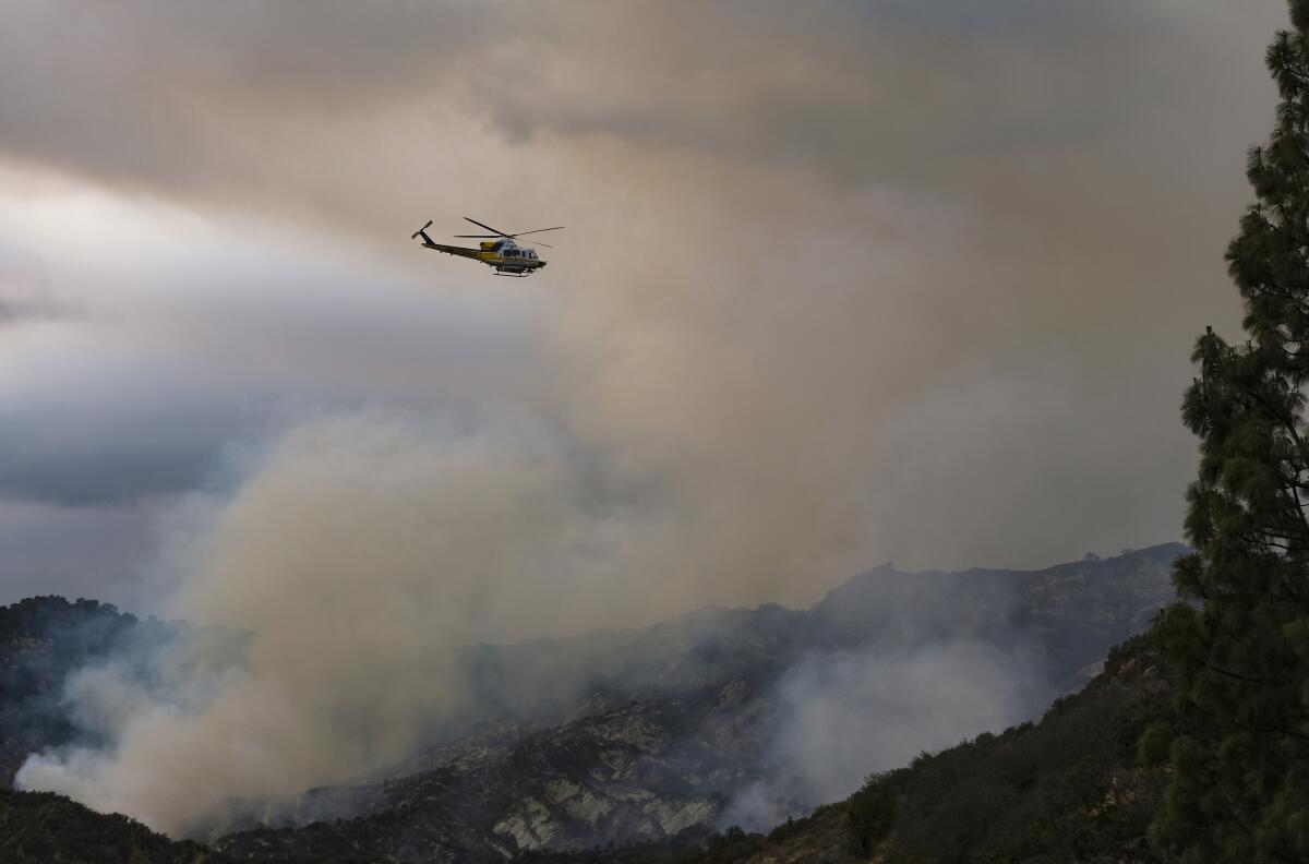 Un helicóptero sobrevuela un incendio forestal en la zona de Pacific Palisades, en Los Ángeles.
