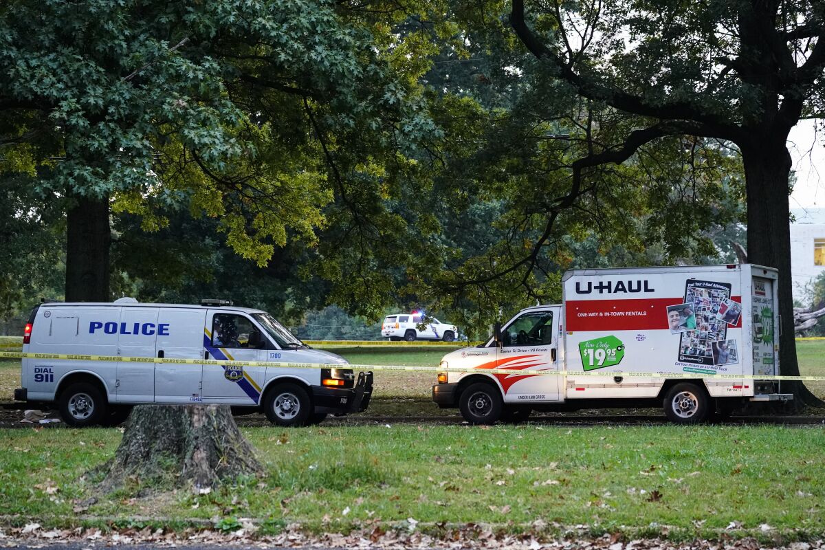 Police vehicles and a U-Haul truck are shown at a crime scene in Philadelphia, Monday, Oct. 4, 2021. Police in Philadelphia say a nurse fatally shot his co-worker at a hospital, fled the scene and was shot in a gunfight with police that wounded two officers. After the shooting, the gunman left the hospital in a U-Haul box truck. A short time later, four officers were alerted to the suspect's location by a passerby near a school. (AP Photo/Matt Rourke)