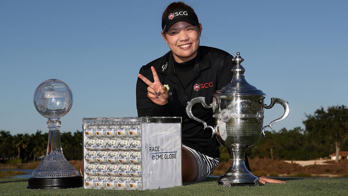 Ariya Jutanugarn poses with the Rolex Player of the Year trophy, the CME Race for the Globe trophy and a box of one million dollars in cash after the final round of the CME Group Tour Championship on Sunday.
