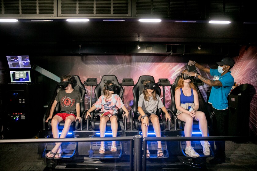 A group of kids rides on a virtual reality machine