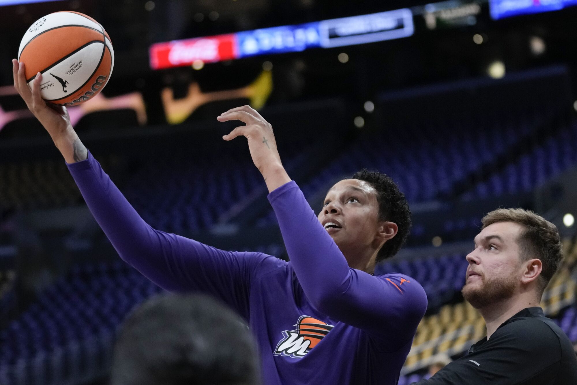 Phoenix Mercury center Brittney Griner shoots a ball under pressure from a staff member as she warms up