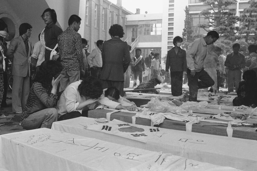 Families and relatives gather around the coffins of dead protesters at provincial headquarters in Gwangju (Kwangju), South Korea, May 23, 1980, some 250 kilometers south of Seoul, South Korea. About 65 people were killed during anti-government protests. (AP Photo/Kin Chon Kil)