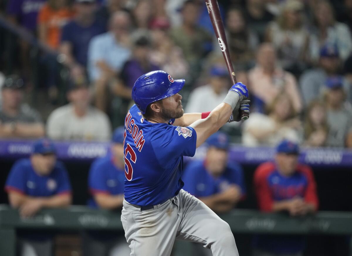Chicago Cubs' Patrick Wisdom follows the flight of his double to drive in three runs off Colorado Rockies starting pitcher Jon Gray in the fifth inning of a baseball game Wednesday, Aug. 4, 2021, in Denver. (AP Photo/David Zalubowski)