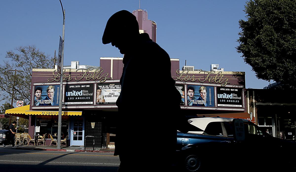 A pedestrian walks past the Los Feliz Theater on Vermont Avenue, a landmark of the Los Feliz neighborhood of Los Angeles. Today, no one can seem to agree if using the Spanish pronunciation for the area is respectful -- or pretentious.