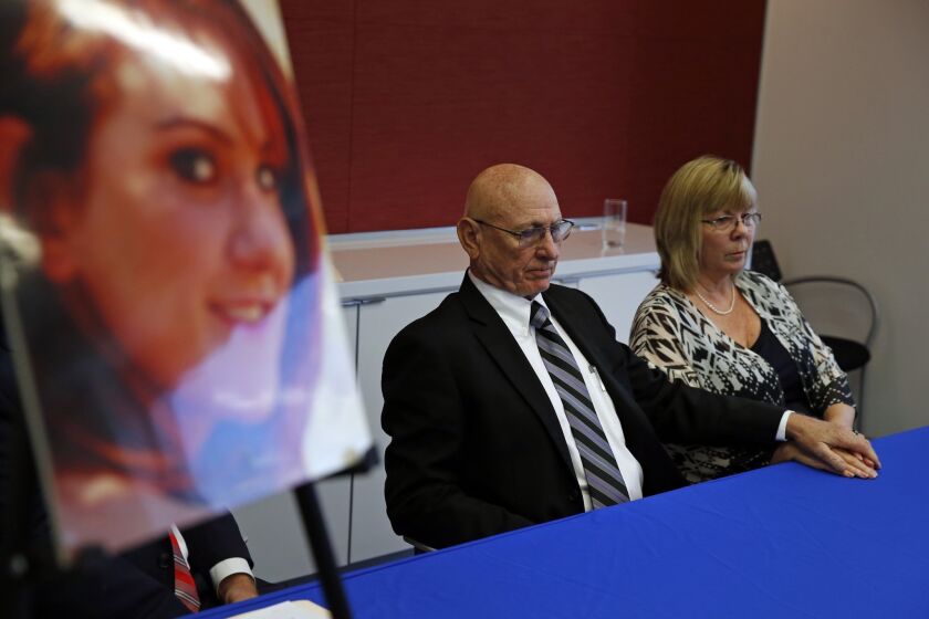 Lonnie and Sandy Phillips appear at a news conference to announce their lawsuit alongside a portrait of daughter Jessica Ghawi, who was killed in the 2012 Aurora theater shooting. They are suing the online companies that sold ammunition and other gear to shooter James E. Holmes.