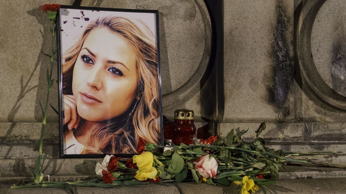 A portrait of slain television reporter Viktoria Marinova is placed on the Liberty Monument next to flowers and candles during a vigil in Ruse, Bulgaria, on Oct. 9.