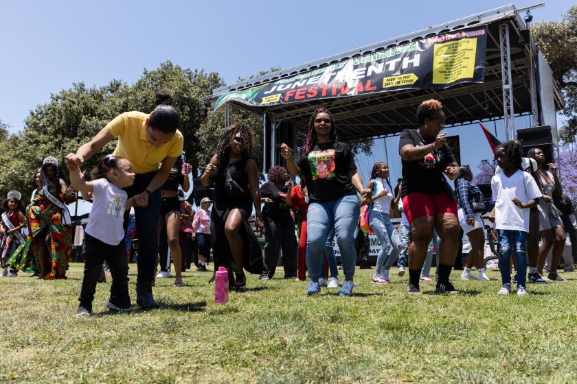 Attendees dance to “Cupid Shuffle” during the Cooper Family Foundation’s Juneteenth celebration at Memorial Park in the Logan Heights neighborhood on Saturday, June 17, 2023. The event was started by Sidney Cooper Sr., a local businessman and community leader who has long celebrated and popularized Juneteenth in San Diego. His family continues to host the holiday event every year.