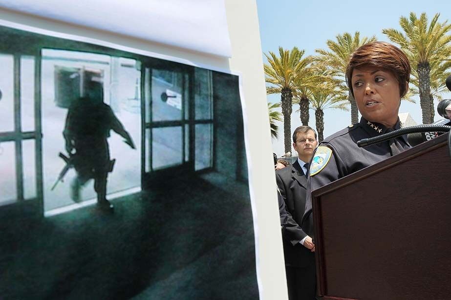 Santa Monica Police Chief Jacqueline Seabrooks talks to reporters next to a surveillance photo of the suspected gunman entering the Santa Monica College library.