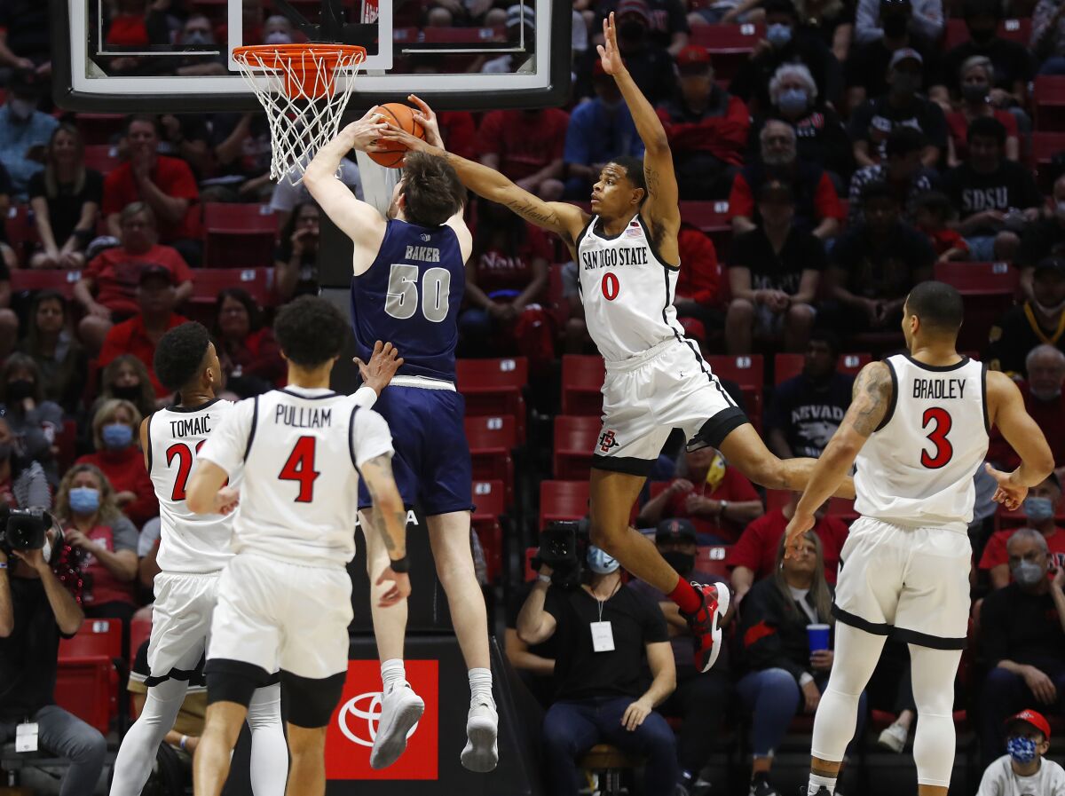 San Diego State's Keshad Johnson blocks a shot by Nevada's Will Baker on Sunday at Viejas Arena.