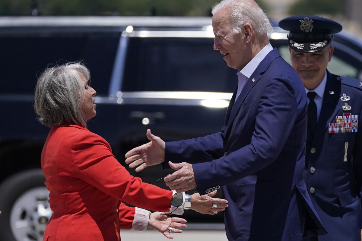 New Mexico Gov. Michelle Lujan Grisham, left, greets President Joe Biden at Kirtland Air Force Base during a trip to meet with state and local officials on the New Mexico wildfires, Saturday, June 11, 2022, in Albuquerque, N.M. (AP Photo/Evan Vucci)