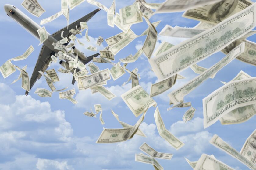Money falling in sky under airplane