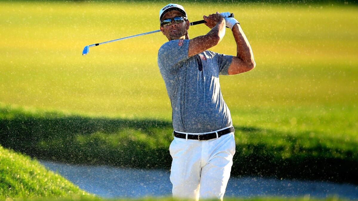 Adam Scott of Australia plays his second shot on the par-five 18th hole out of a fairway bunker during the third round of the Honda Classic on Saturday.