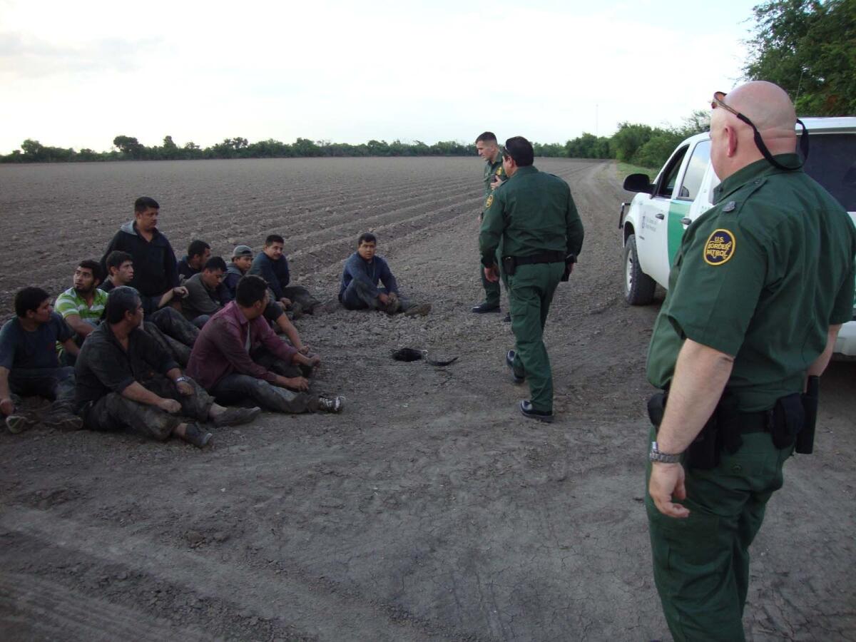 Border Patrol division chief Robert Duff, right, and other agents round up migrants in the Rio Grande Valley.